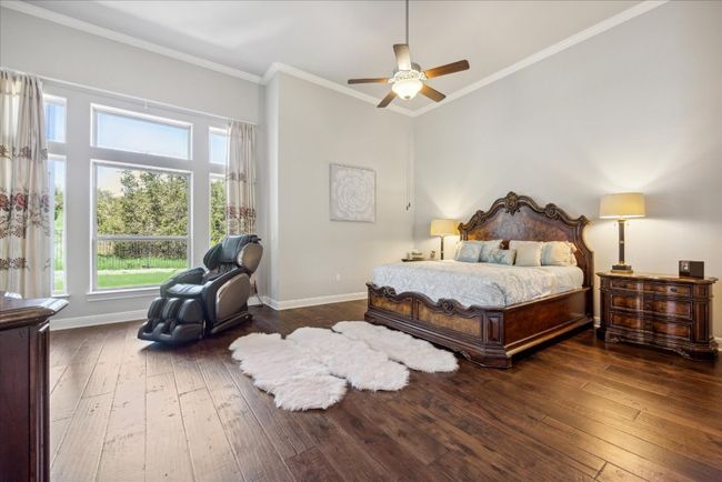 Bedroom featuring baseboards, crown molding, a ceiling fan, and hardwood / wood-style floors | Image 13