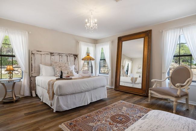 Bedroom featuring a chandelier, multiple windows, and dark wood-style floors | Image 19