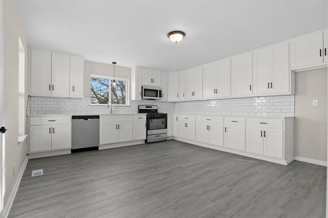 Kitchen with stainless steel appliances, tasteful backsplash, and light countertops | Image 4