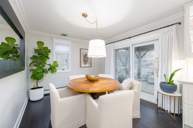 Dining room featuring dark wood-style floors, crown molding, visible vents, and plenty of natural light | Image 22