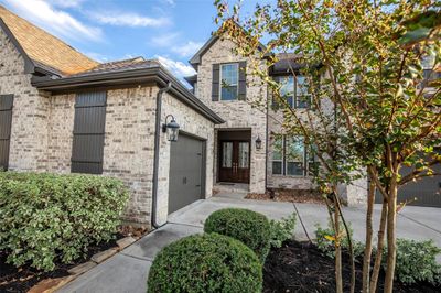 Double front door with glass panels. It's complemented by well-kept landscaping and beautiful tree at the front. | Image 2