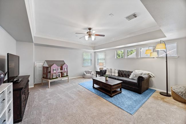 Massive gameroom with tray ceilings and crown molding offers beautiful transom windows filled with natural light. | Image 33