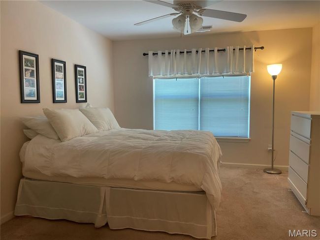 Bedroom with light carpet, baseboards, and ceiling fan | Image 12