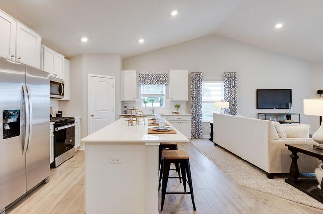 A true designer kitchen; Quartz countertops complimented by tile backsplash, a massive island, plenty of cabinet space, plus a walk-in pantry! Photo of model, colors and options will vary. | Image 4