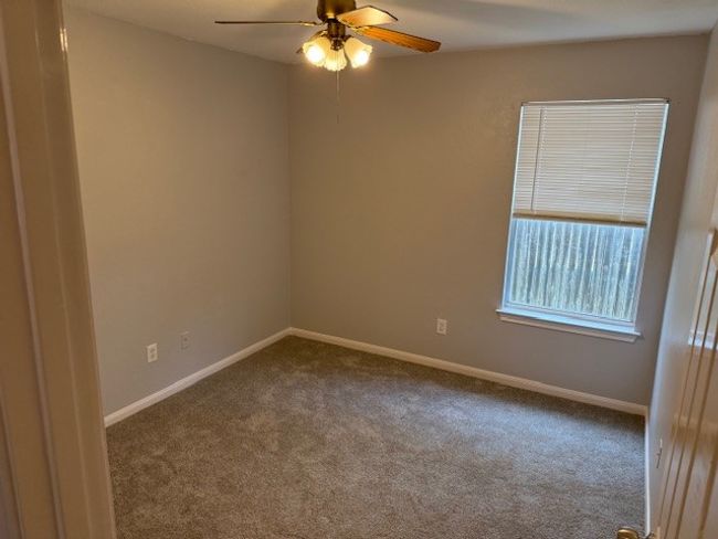 Carpeted empty room with a ceiling fan and baseboards | Image 4