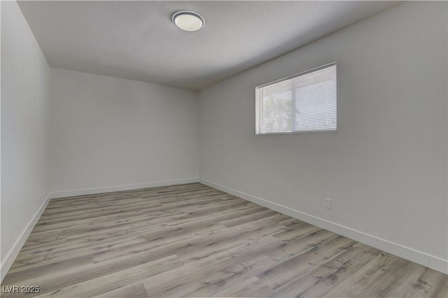 Empty room featuring baseboards, wood finished floors, and a textured ceiling | Image 26