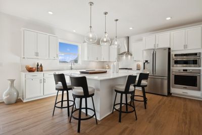 (Photo of a decorated model, actual homes finishes will vary) Welcome to the Washburn! This spacious gourmet kitchen features a large center island, quartz countertops, LVP floors, stainless appliances and more. | Image 2