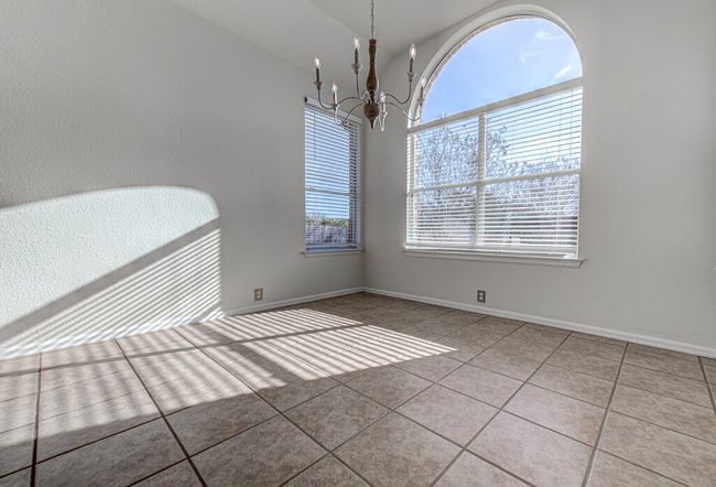 Tiled empty room featuring baseboards and a chandelier | Image 12
