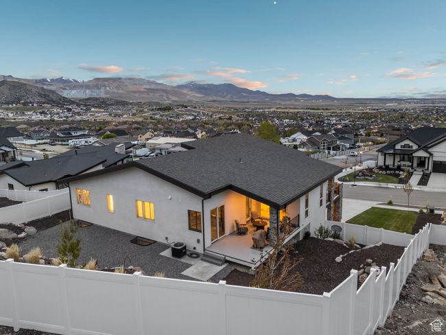 Rear view of house with a mountain view, stucco siding, a fenced backyard, and roof with shingles | Image 72