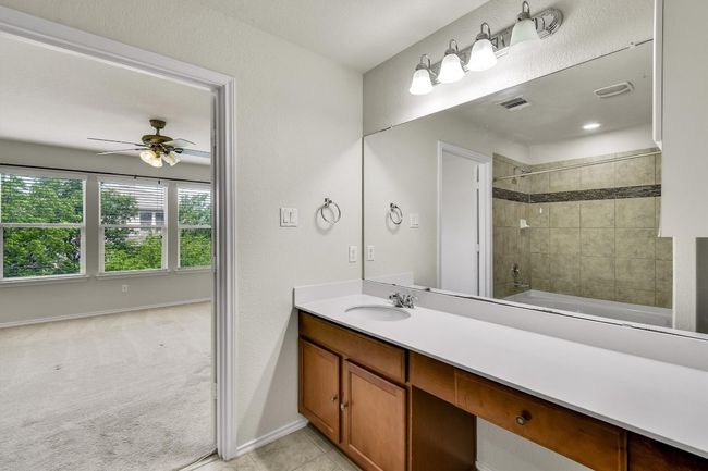 Bathroom featuring tile patterned floors, bathing tub / shower combination, visible vents, vanity, and ceiling fan | Image 25