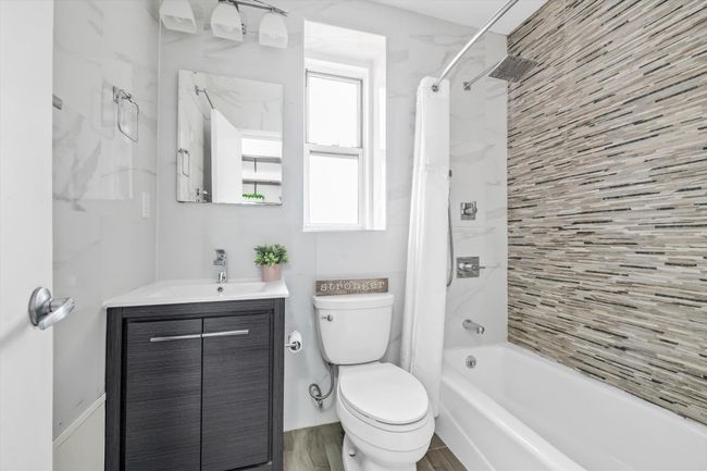 Bathroom featuring vanity, shower / bath combination with curtain, and wood finished floors | Image 10