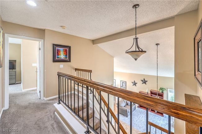 Corridor with an upstairs landing, baseboards, carpet floors, and a textured ceiling | Image 24