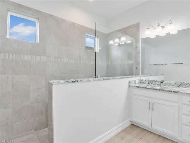 Bathroom featuring a tile shower, vanity, and a healthy amount of sunlight | Image 22