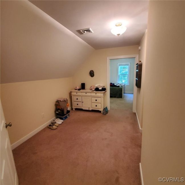 Bonus room featuring visible vents, light colored carpet, baseboards, and lofted ceiling | Image 44