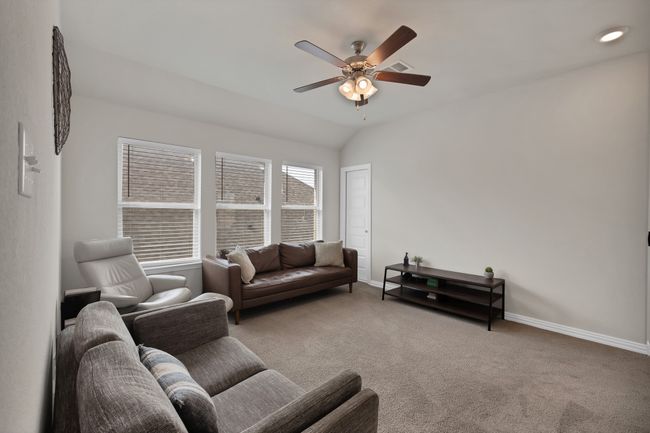 Living room with baseboards, carpet floors, lofted ceiling, and a ceiling fan | Image 27