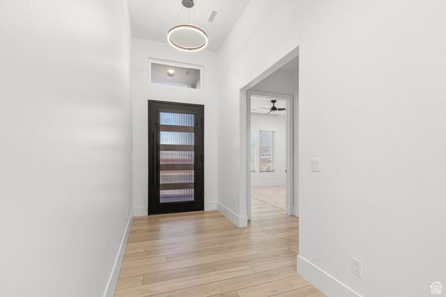 Foyer entrance with light wood-type flooring, baseboards, a ceiling fan, and visible vents | Image 14