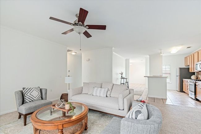 The living room seamlessly flows into the kitchen. | Image 6