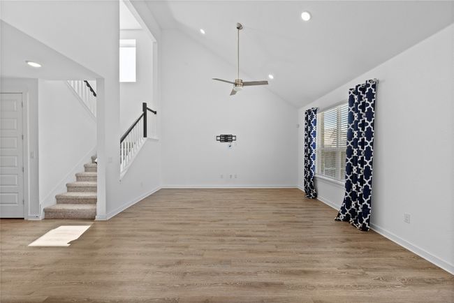 Unfurnished living room with light wood-style flooring, high vaulted ceiling, stairs, and recessed lighting | Image 19