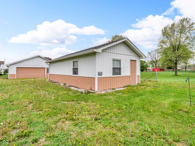 view of property exterior featuring a lawn, an outdoor structure, and a detached garage | Image 5