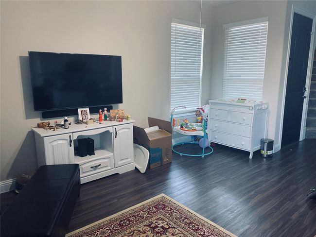 Living area featuring dark wood-style flooring and baseboards | Image 10
