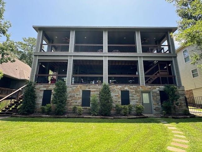 Elegant rear view with stepping stones leading to the elevator hallway and quick access to the lower porch via left-side stairs. Features a solar-powered, remote-controlled gate on the right for added convenience. | Image 40