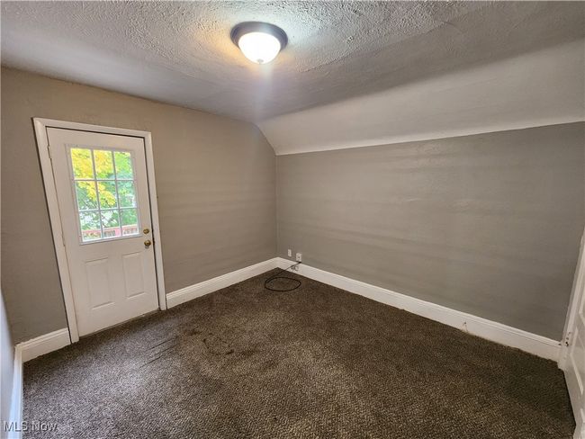 Bonus room featuring lofted ceiling, a textured ceiling, and dark carpet | Image 19