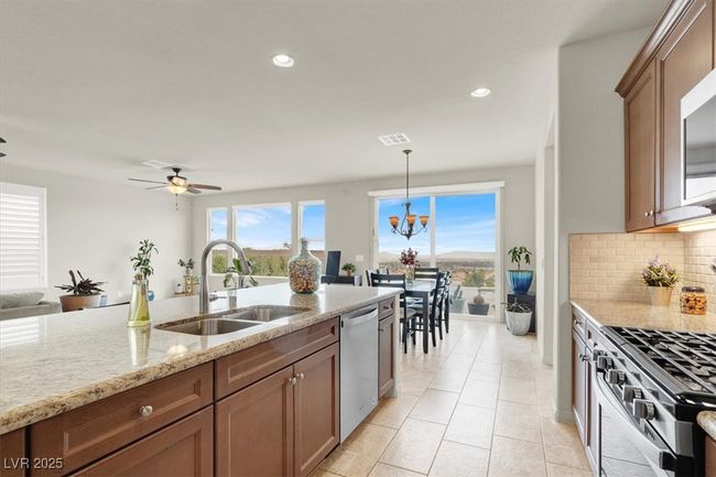 Kitchen featuring decorative backsplash, light stone counters, stainless steel appliances, decorative light fixtures, and recessed lighting | Image 23