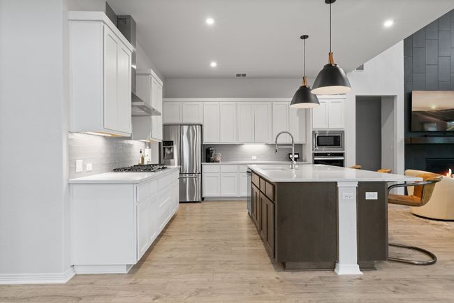The kitchen includes an abundance of cabinetry, a pantry, and a beautiful backsplash throughout. | Image 14