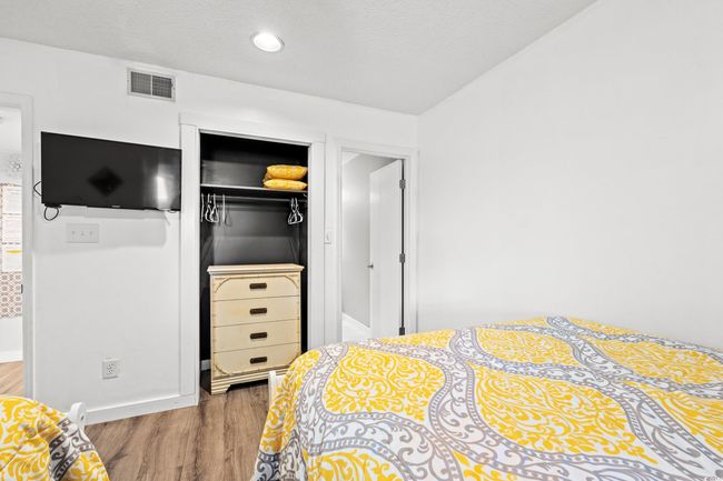 Bedroom with wood finished floors, a closet, a textured ceiling, and recessed lighting | Image 19