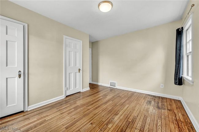 Unfurnished bedroom featuring baseboards, hardwood / wood-style floors, and visible vents | Image 36