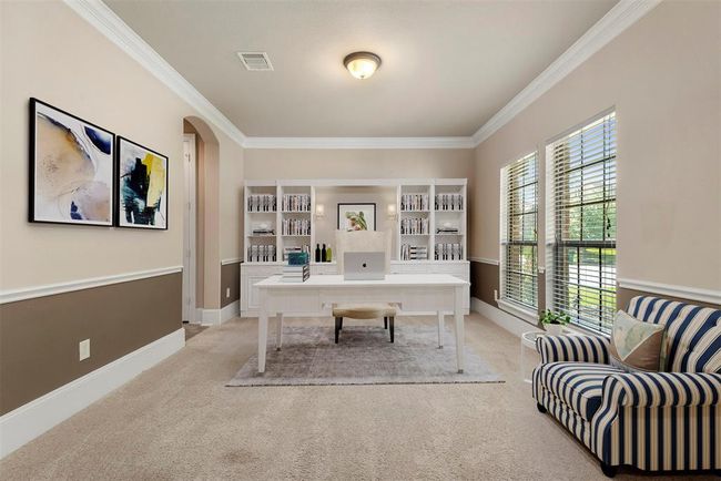 Flex room with crown molding at the front of the home staged as a study. This room is full of sunlight and would make the perfect home office. Plenty of room for multiple work stations. Virtually staged. | Image 8