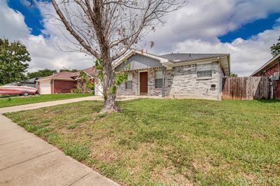 View of front facade with a front yard and a garage | Image 3