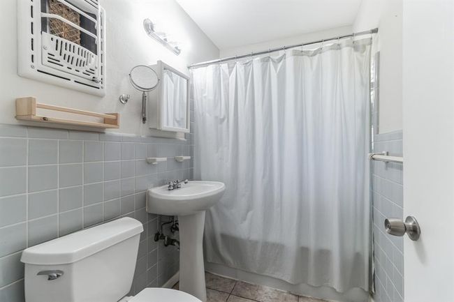 Bathroom featuring tile walls, tile patterned floors, and shower / tub combo | Image 11