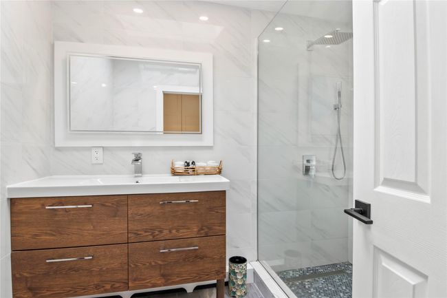 Bathroom with vanity, a walk in shower, and tile walls | Image 25