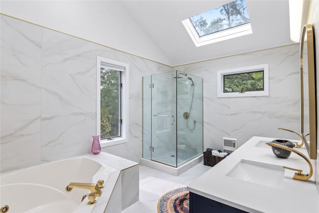 Bathroom featuring a marble finish shower, a jetted tub, lofted ceiling, plenty of natural light, and tile walls | Image 19