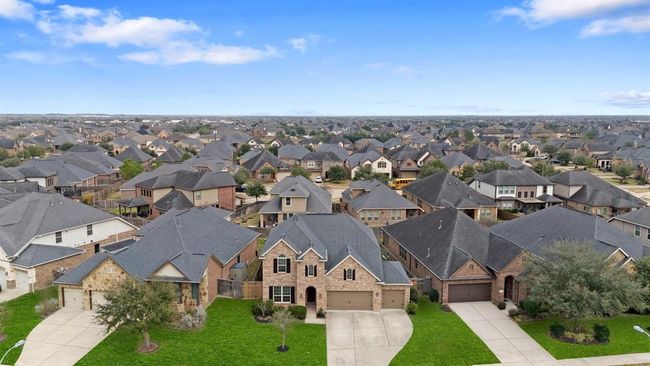 Take in the stunning aerial view of the front of this home, offering a glimpse of the beautiful neighborhood and its inviting surroundings. | Image 21