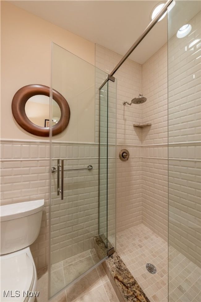 Guest Bathroom 2 featuring tile patterned flooring, tile walls, a wainscoted wall, toilet, and vanity | Image 45
