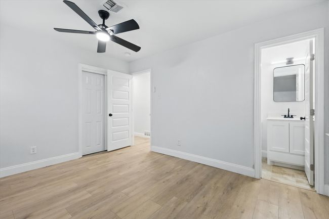 Unfurnished bedroom with light wood-style flooring, baseboards, and a sink | Image 13