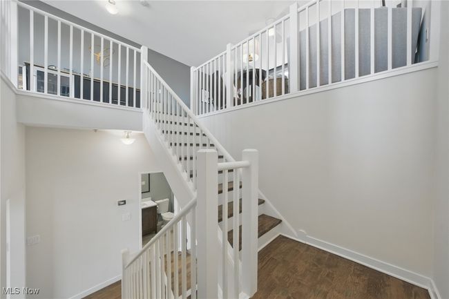 Stairs featuring wood finished floors, a towering ceiling, and baseboards | Image 28