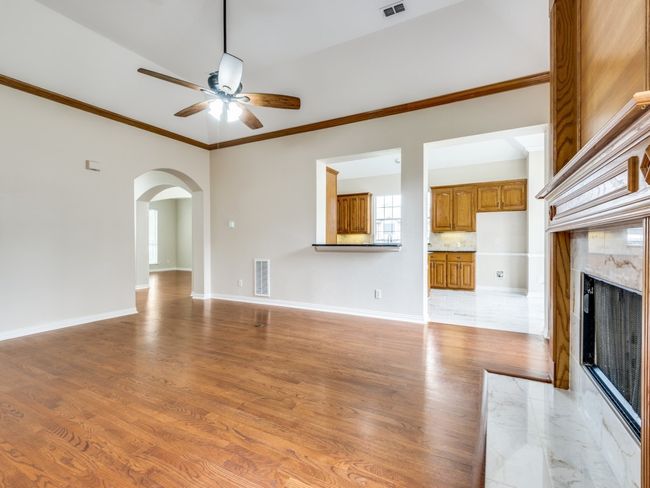 This home has a spacious family room with a kitchen pass-through. The pass-through features a nice size counter that will hold bar stools and/or can be used as a serving area for entertaining. | Image 10