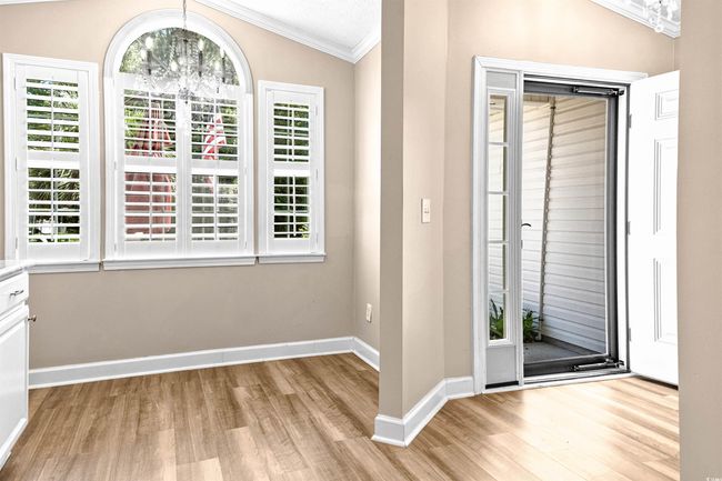 Foyer entrance featuring crown molding, vaulted ceiling, baseboards, an inviting chandelier, and light wood-style flooring | Image 10