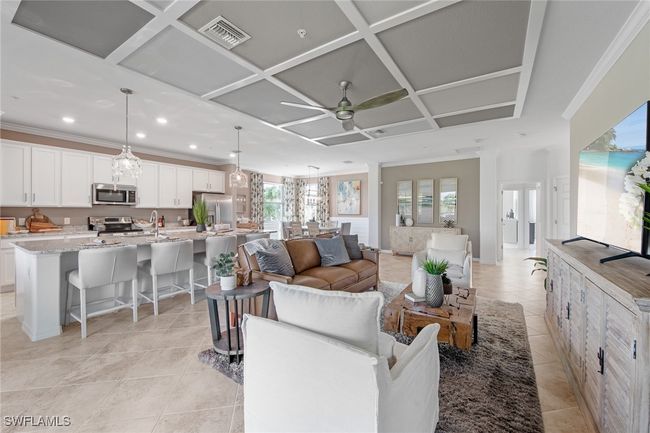Living area with light tile patterned floors, ornamental molding, a ceiling fan, visible vents, and coffered ceiling | Image 13