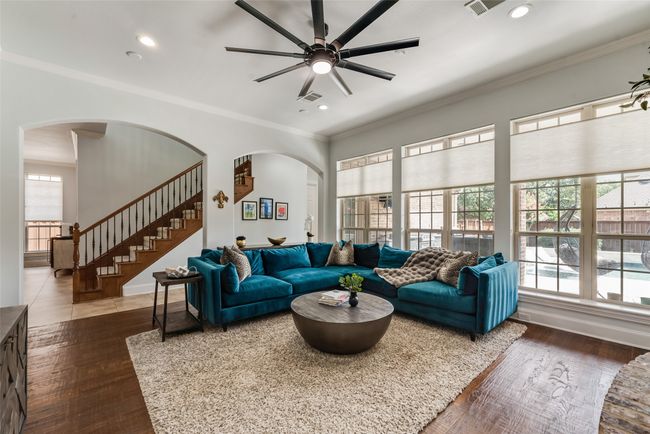 Living area featuring arched walkways, ceiling fan, stairs, crown molding, and recessed lighting | Image 12