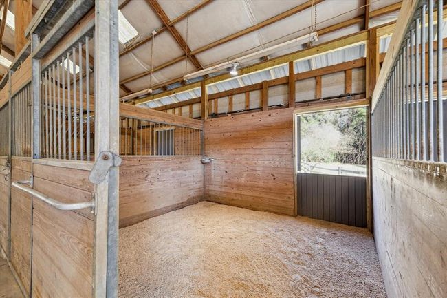Each of the five individual horse stalls measure 12'x12' with a hard, natural clay foundation topped with sand and rubber mats providing a comfortable place for standing as well as sleeping. The JW Hall stall system and doors are hot dipped galvanized steel with solid round bars and tongue and groove lumber designed to withstand even the wildest horses. | Image 43