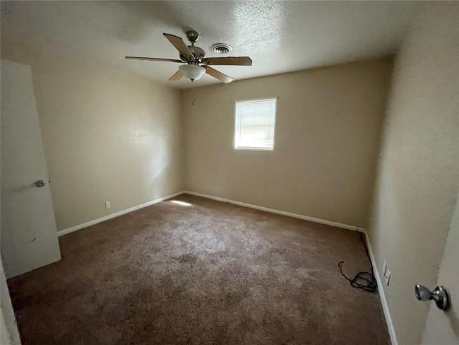 Carpeted spare room featuring ceiling fan and baseboards | Image 8