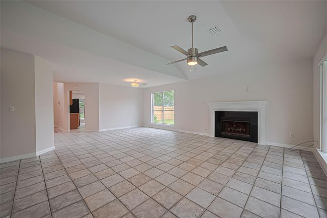 Open-concept dining and living area filled with natural light and offering beautiful views of the pool and backyard oasis. | Image 9