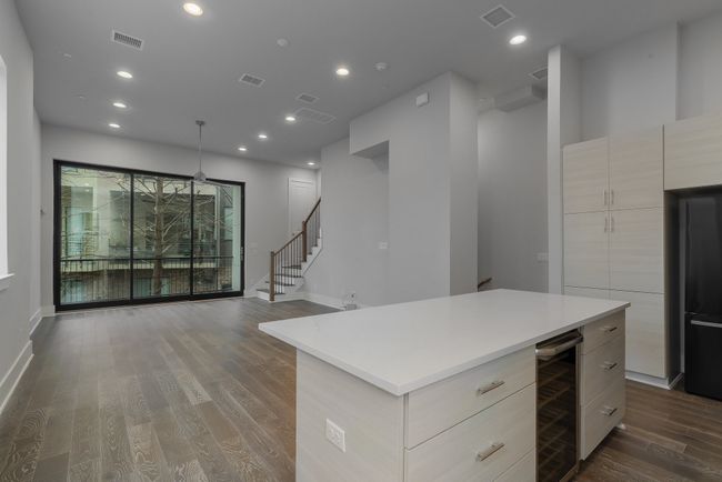 Kitchen featuring modern cabinets, visible vents, wine cooler, and light countertops | Image 16
