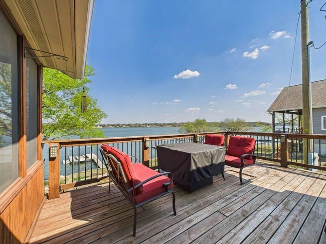 Wooden deck featuring a water view, furniture and firepit table | Image 12