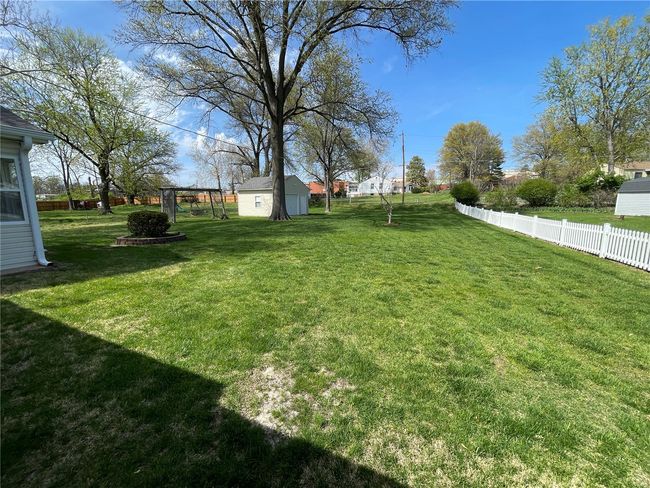 View of yard featuring a storage shed, an outbuilding, and fence | Image 46