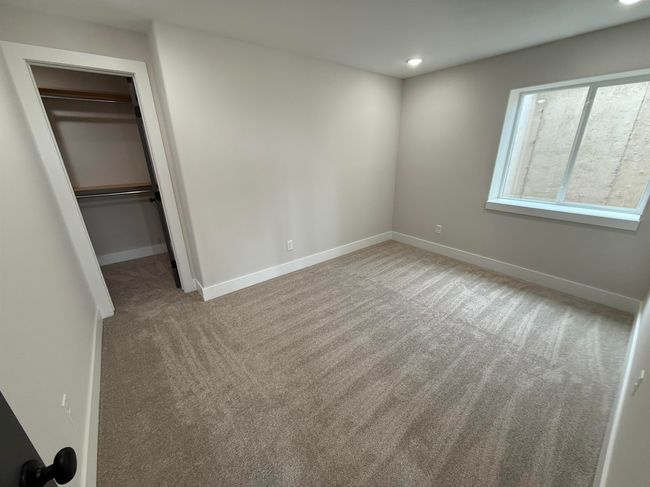 Unfurnished bedroom featuring carpet flooring, baseboards, a walk in closet, recessed lighting, and a closet | Image 13